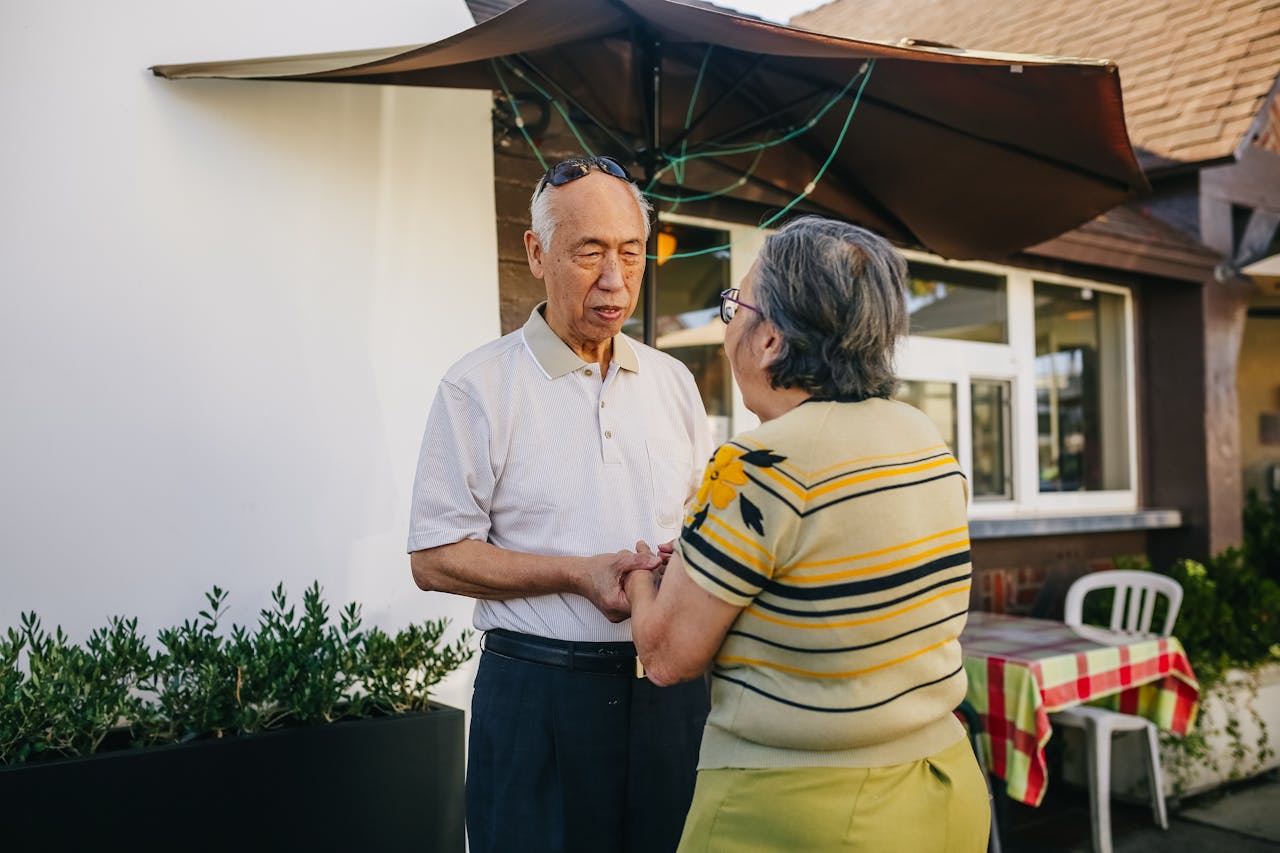 Inter-Unit Leak Disputes in Singapore – Responsibilities, Resolution Process and What You Need to Know Senior Asian couple holding hands and expressing love and affection in a sunny outdoor setting.