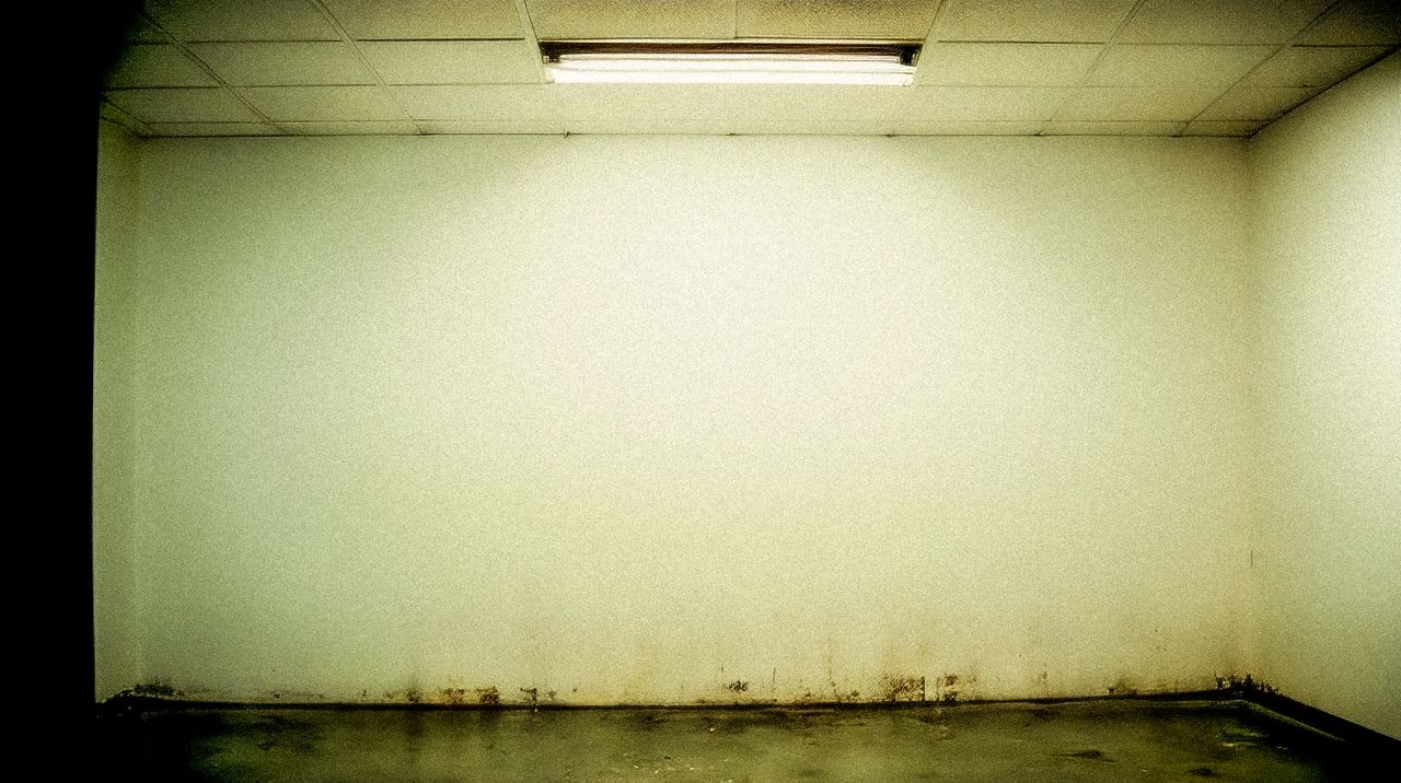 Basement & Below-Grade Leaks in Singapore – Causes, Hydrostatic Pressure and Diagnosis Moody grunge-style room with stained walls and fluorescent ceiling light.